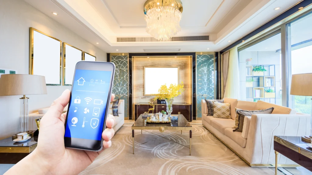 Person holding smartphone with smart home interface in a modern living room setting