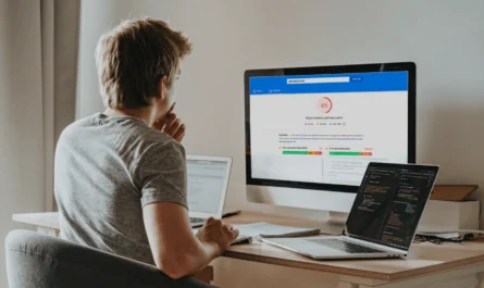 Person analyzing website speed optimization on multiple devices with PageSpeed Insights showing a low score